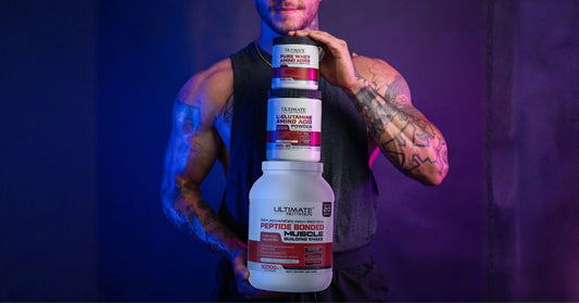 Muscular person holding three stacked Ultimate Nutrition supplement containers including Pure Whey Amino Acids L Glutamine Amino Acid Powder and 50 Advanced High Protein with blue and purple lighting creating a strong fitness themed atmosphere