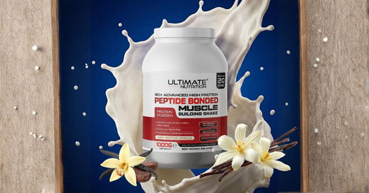 A tub of Ultimate Nutrition Peptide Bonded Muscle Building Shake in high protein vanilla flavour is centred against a dynamic splash of milk on a dark blue background. The product is framed by vanilla flowers and vanilla bean pods at the base, with a rust