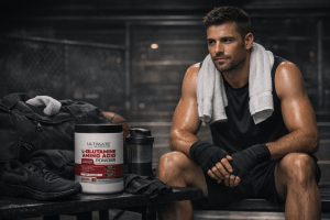 Athlete resting on a gym bench with a container of pharmaceutical grade L Glutamine amino acid powder used for muscle recovery and performance support at Ultimate Nutrition