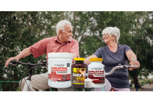 Older adults riding bicycles outdoors with Ultimate Nutrition creatine supplements displayed in the foreground, highlighting strength and vitality for active aging.