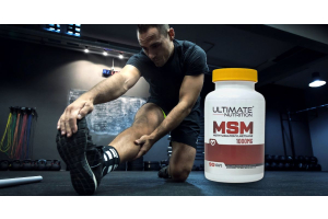 athlete stretching on a gym floor beside an ultimate nutrition msm 1000mg supplement to illustrate what research shows about msm for joint health for the article msm for joint health what the research shows