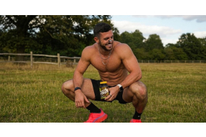 muscular athlete outdoors holding an ultimate nutrition testo power supplement to illustrate whether testosterone boosters actually work for the article do testosterone boosters actually work