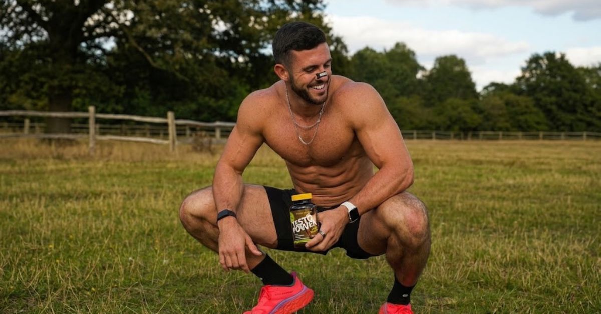 muscular athlete outdoors holding an ultimate nutrition testo power supplement to illustrate whether testosterone boosters actually work for the article do testosterone boosters actually work